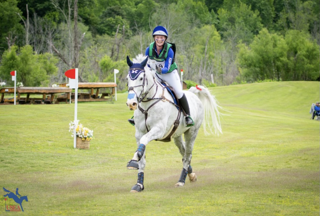 Riders patting horse while running an eventing course.